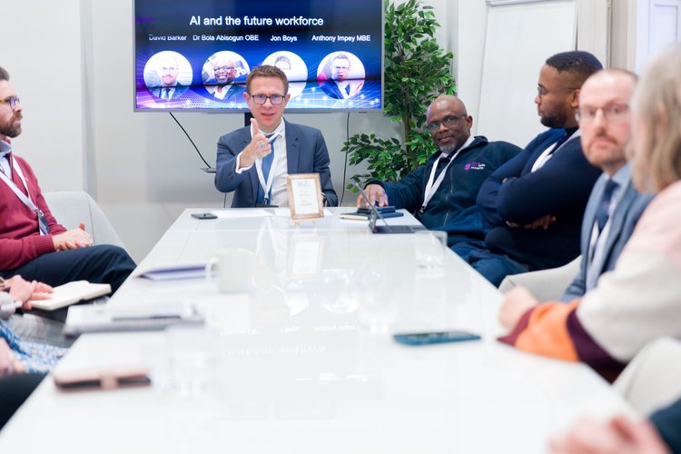 Anthony Impey chairs a business discussion. He sits at the top of a long white table, looking towards someone who is out of shot
